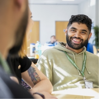 A young male laughing with colleagues