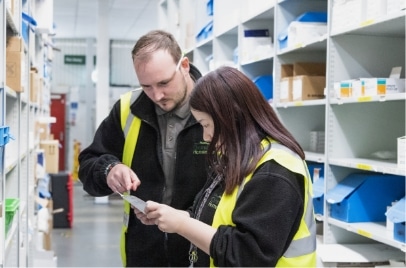 An apprentice and her mentor in a warehouse